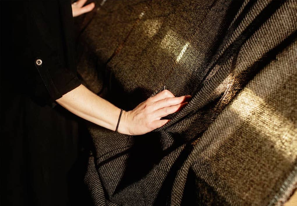 Female hands stretching out brown fabric over a wooden board